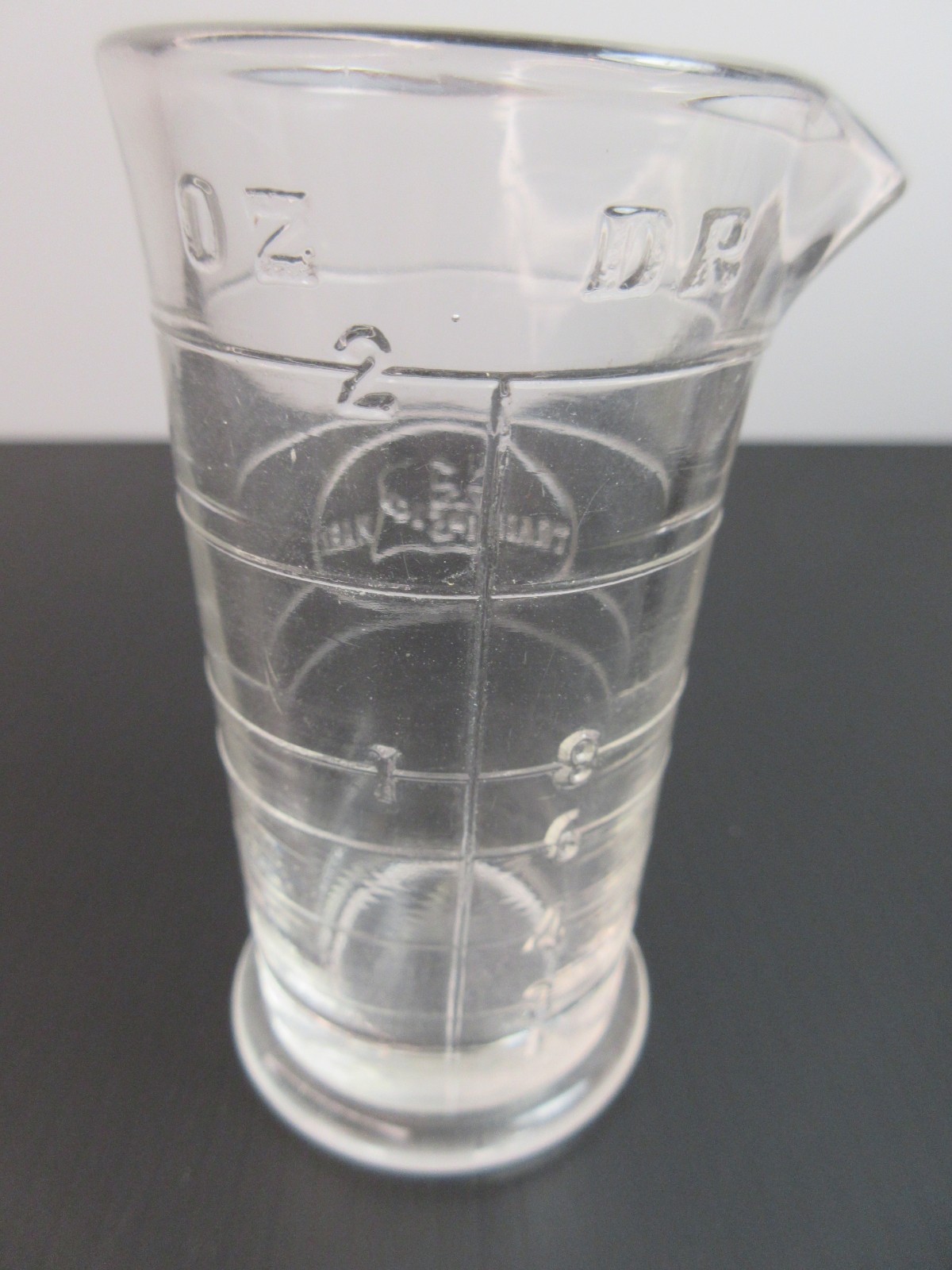 1930’s ENSIGN UK Footed Glass Embossed APOTHECARY MEASURE BEAKER Ounces & Drams