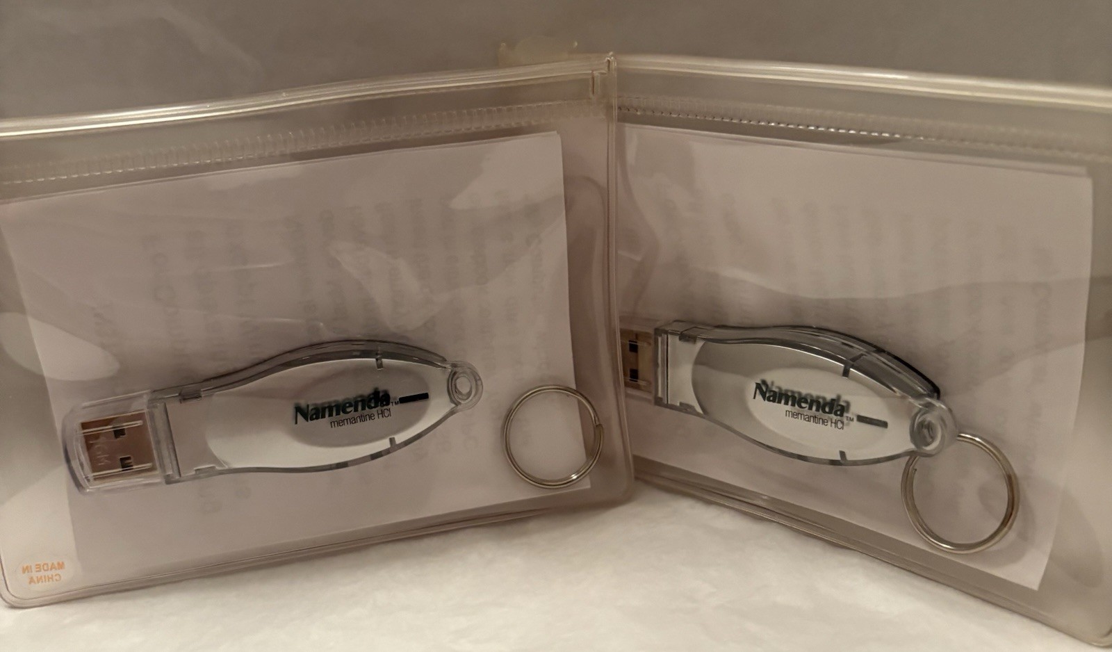 VTG LOT OF 2 NAMENDA USB FLASH MEMORY DEVICES + KEYRINGS PHARMA REP LOGO NEW