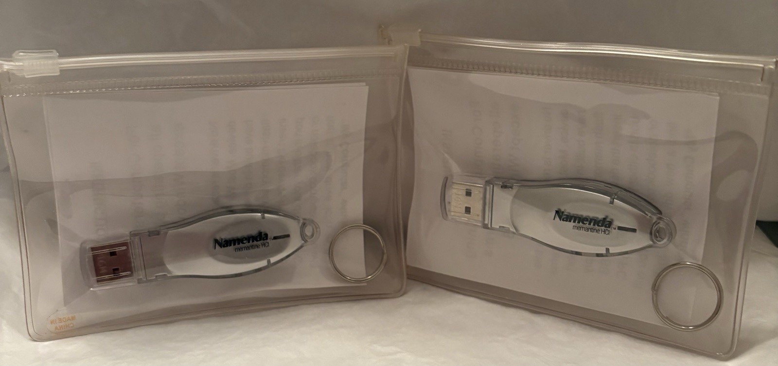VTG LOT OF 2 NAMENDA USB FLASH MEMORY DEVICES + KEYRINGS PHARMA REP LOGO NEW