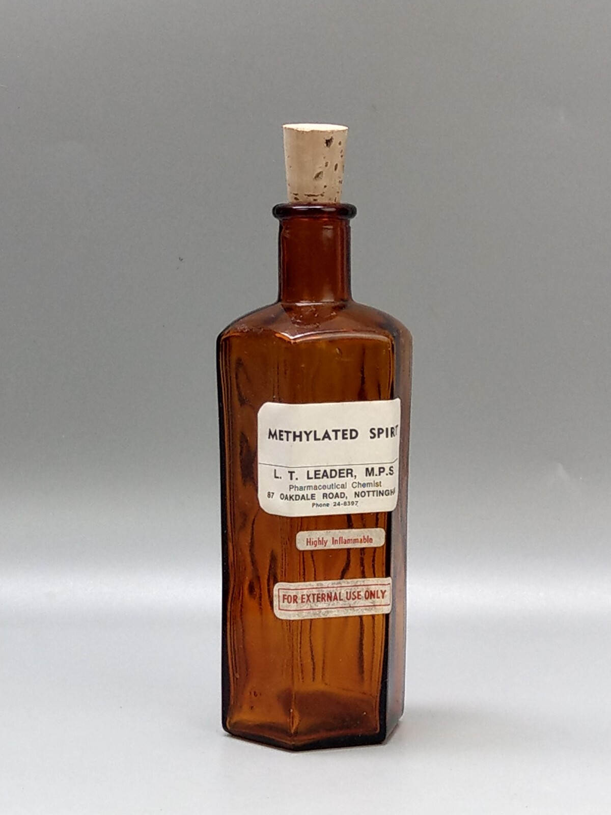 Vintage brown glass chemist bottle with label: Methylated Spirit L.T. Leader